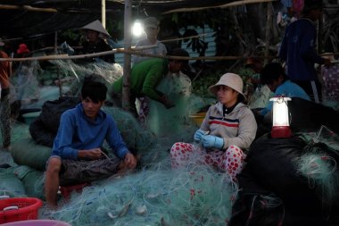 Kumsalda erken sabah saat çalışan insanlar