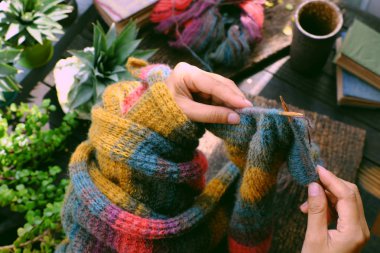 Top view at home balcony, hand hold piece of paper, knit colorfu
