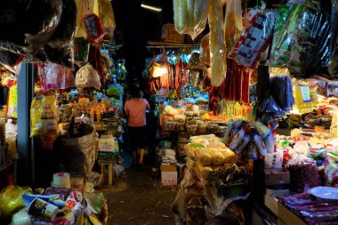 Indoor dried food market with many stalls in yellow lamp
