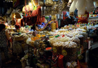 Indoor dried food market with many stalls in yellow lamp