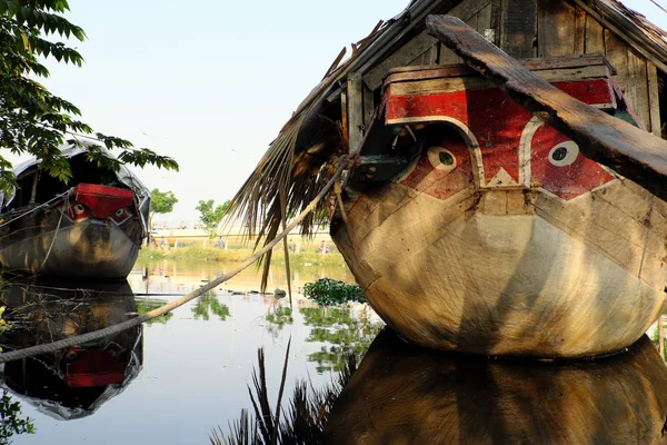 Wooden boat with dried leaves roof, eyes looking straight moorin — Stok fotoğraf