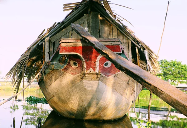 Wooden boat with dried leaves roof, eyes looking straight moorin — ストック写真