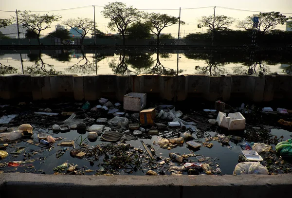 Pollution river from litter at Ho Chi Minh city, Viet Nam, many trash from plastic bag, bottle, packaging in water make dirty canal at morning