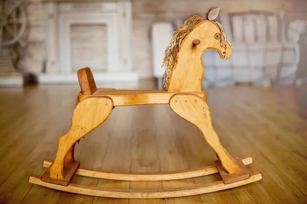 Nice vintage classic wooden rocking horse chair on wooden floor shot in a blurred vintage interior background. — Stock Photo, Image