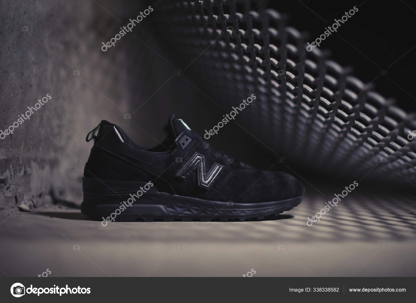 Black New Balance 574 sneakers shot outdoor on dark industrial background. Illustrative editorial close up photo of casual sport shoes shot in Krasnoyarsk, Russia - January 9, 2018 – Stock Editorial Photo © Alavanta #338338582
