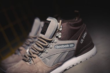 Kahverengi gri bej renkli Reebok GI 6000 orta boy spor ayakkabıları karanlık endüstriyel arka planda açık havada çekildi. Rusya 'nın Krasnoyarsk şehrinde 10 Ocak 2018' de çekilen spor ayakkabılarının resimli yakın çekim fotoğrafı.