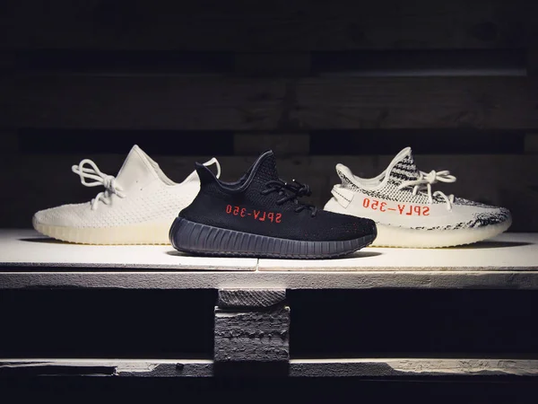 Adidas Yeezy Boost 350 v2 Sply спортивные туфли в 3 различных цветов сняты на темном деревянном фоне. Закройте глаза на недоброжелателей. Красноярск, Россия - 6 июля 2017 — стоковое фото