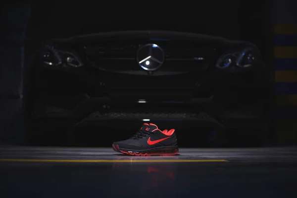 Perfekt Nike Air Max 2017 sportskor sköt nära Mercedez Benz bil på mörk bakgrund. Sport och fritidskläder koncept. Krasnojarsk, Ryssland - 10 januari 2018 — Stockfoto