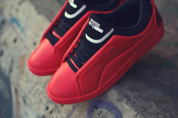 Beautiful red and black sneakers McQ By Alexander McQueen x Puma Brace Lo shot outdoor on colorful abstract background. Close up view of casual sport shoes. Krasnoyarsk, Russia - December 19, 2017 — 스톡 사진