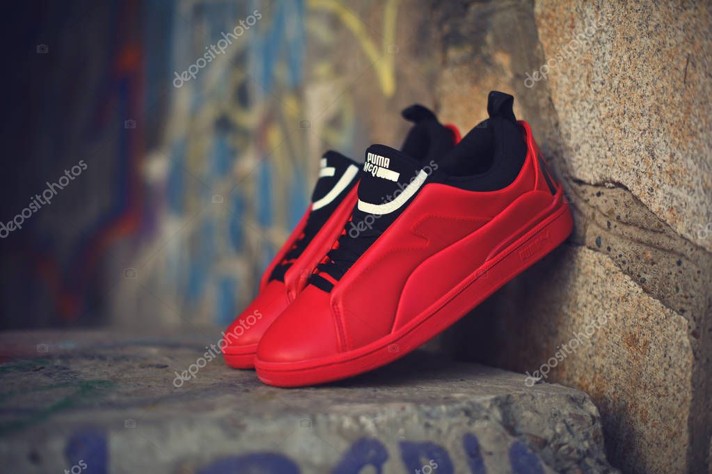 Beautiful red and black sneakers McQ By Alexander McQueen x Puma Brace Lo shot outdoor on colorful abstract background. Close up view of casual sport shoes. Krasnoyarsk, Russia - December 19, 2017