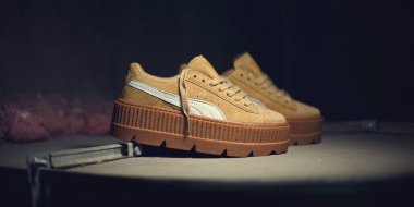 Rihanna 'nın karanlık endüstriyel arka planında güzel Puma Süet Sürüngenleri. Spor ayakkabıları, spor ayakkabıları, spor ayakkabıları. Ayakkabı konsepti. Krasnoyarsk, Rusya - 26 Aralık 2017