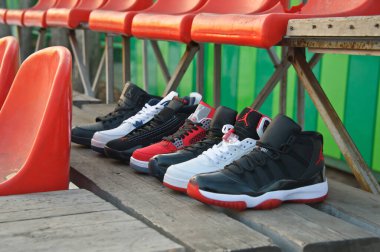 Nike Air Jordan series basketball shoes collection in different colors and models shot on wooden flooring at colorful background. Sport footwear concept. Krasnoyarsk, Russia - February 7, 2015 clipart