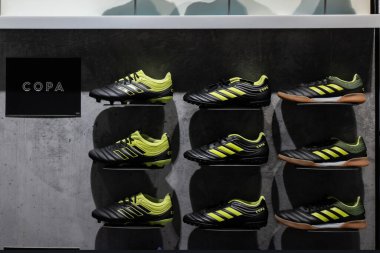 Adidas Copa futbol ayakkabıları: Adidas mağazasının vitrininde sıkı zemin kramponları, kapalı sala ayakkabıları ve çekirdek siyah ve güneş sarısı renkli çim ayakkabıları. Krasnoyarsk, Rusya - 3 Haziran 2019