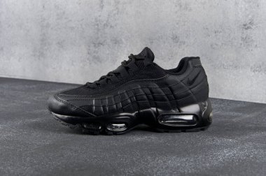 Black Nike Air Max 95 spor ayakkabıları, koşu ayakkabıları, spor ayakkabıları yakın görüş, gri soyut arka planda çekim. Spor ve günlük ayakkabı konsepti. Krasnoyarsk, Rusya - 12 Mayıs 2017