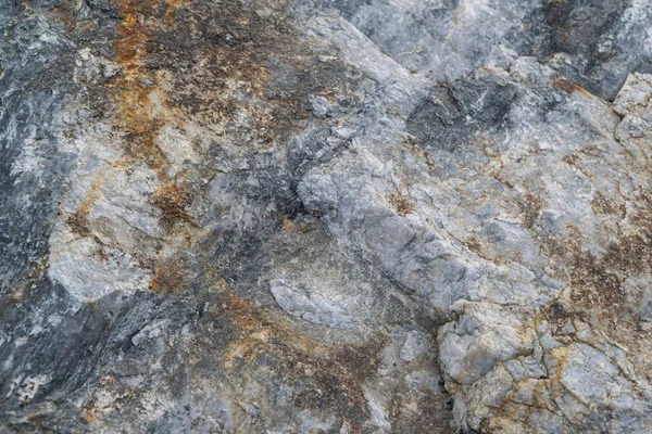 Gold ore texture close-up. Contains quartz, mica, feldspar, chlorite, garnet, carbonate, sulfides and gold. Siberian natural resources deposit. Mineral stone surface abstract background.