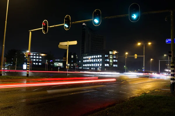 Intersección por la noche con el tráfico borroso por el movimiento — Foto de Stock