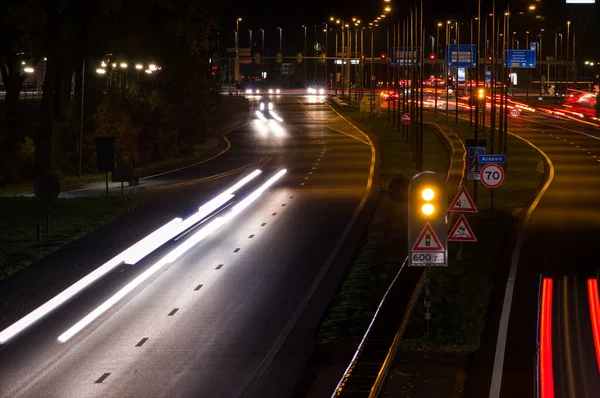 Kruising 's nachts met verkeerslichten en verkeer — Stockfoto