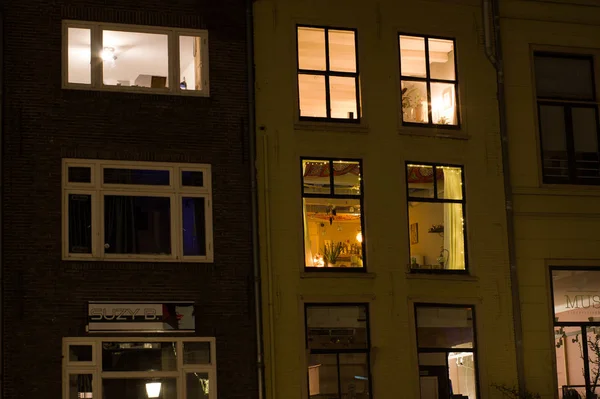 Facades of apartments with illuminated windows at night — Stock Photo, Image