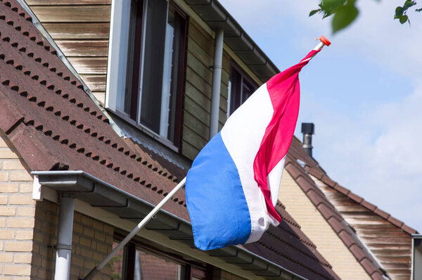 Голландский флаг на фасаде дома во время национального праздника в Нидерландах
