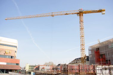 Arnhem, Hollanda - 16 Nisan 2020 Arnhem şehir merkezindeki şantiyede büyük sarı bir vinç