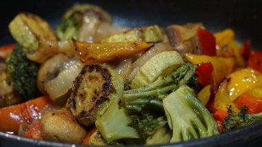 Kırmızı ve sarı dolma biber, yeşil kabak, soğan, yeşil brokoli ve şampiyonlar tavada kızartılır.