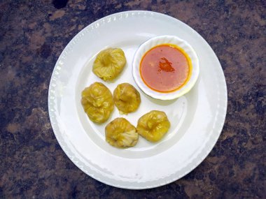 Kırmızı Chutny 'li seksi anneler taştan arka planda beyaz bir tabak koymuşlar.