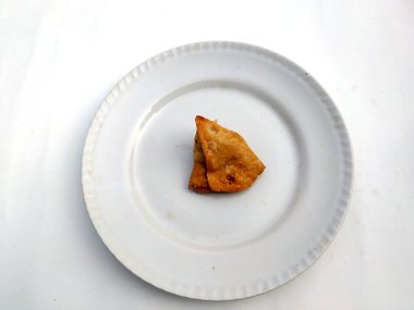 Hindistan çölü taze samosası beyaz arka planda izole edilmiş beyaz tabağa konur.