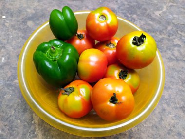 Pek çok taze ve sağlıklı sebze, taştan arka planda plastik bir yakaya konur.