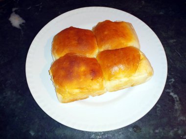 ev yapımı taze ekmek siyah taş arka planda beyaz bir tabağa konur.