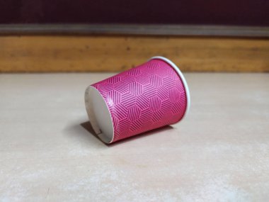 kırmızı renkli kağıt çay fincanı ahşap zemine uzandı.