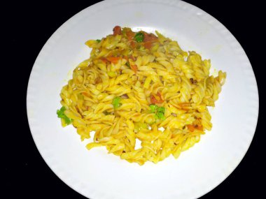 Taştan arka planda beyaz bir tabağa konmuş sarı yenebilir yiyecekler.