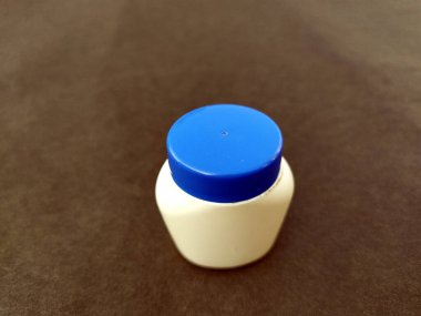 Pürüzsüz bir arka planda izole edilmiş beyaz ve mavi bir plastik şişe