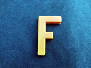 Siyah arkaplanda izole edilmiş İngilizce plastik alfabe harfi