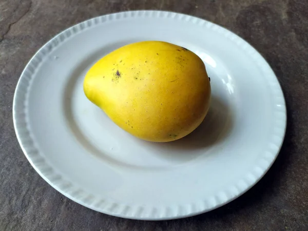 Čerstvé Sladké Žluté Mango Dát Bílého Talíře Kamenném Pozadí — Stock fotografie