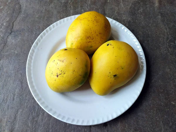 Tuore Makea Keltainen Mango Laittaa Valkoinen Levy Kiven Taustalla — kuvapankkivalokuva