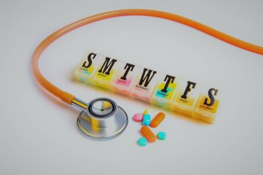 gün hap kutusu ve kapsül ve beyaz arka plan üzerinde stetoskop