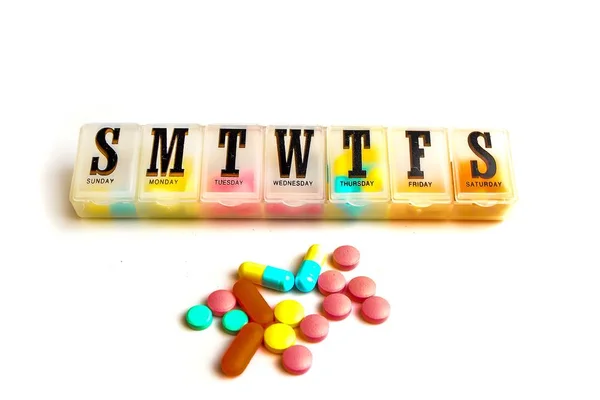 Medicine organizer and pills on white background — Stock Photo, Image