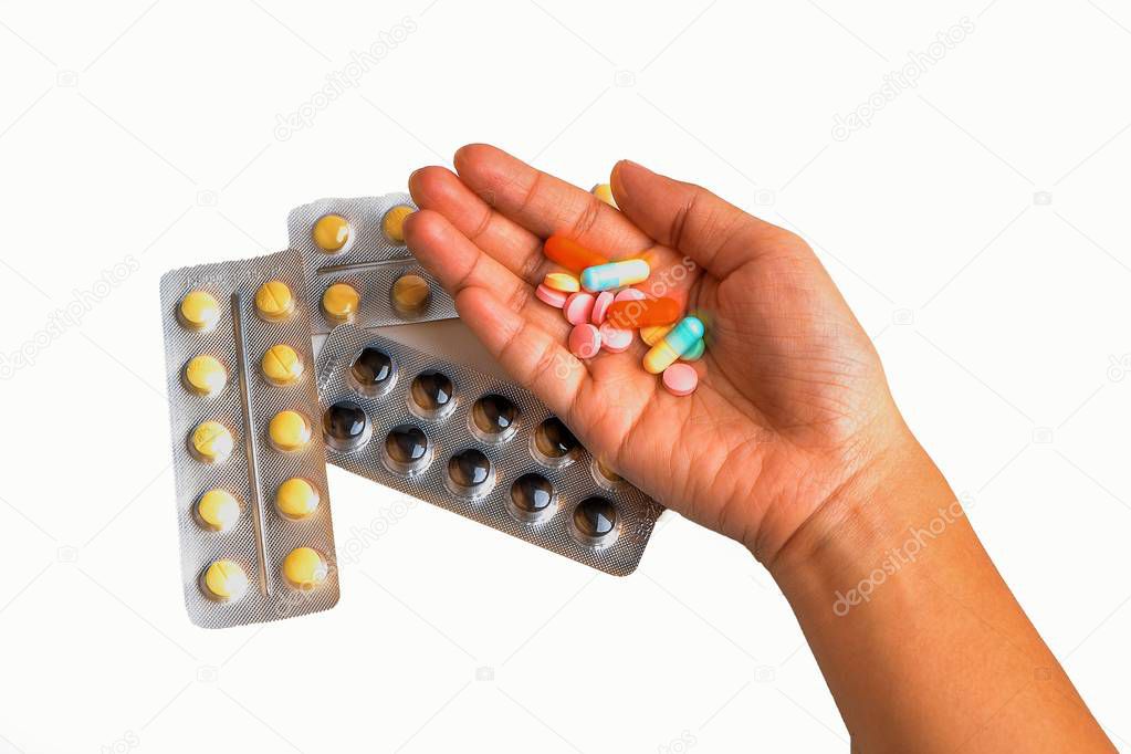 hand holding pills on isolated white background