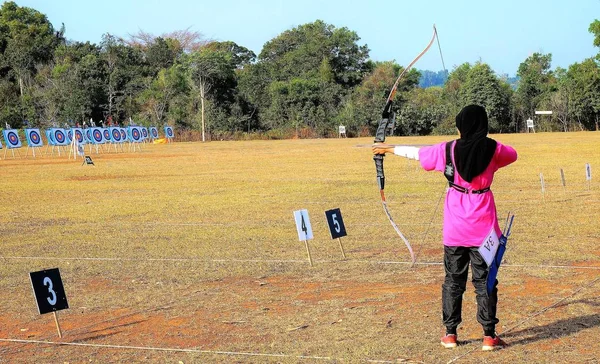 Uma pessoa está atirando com curva re arco em um alvo de tiro com arco — Fotografia de Stock