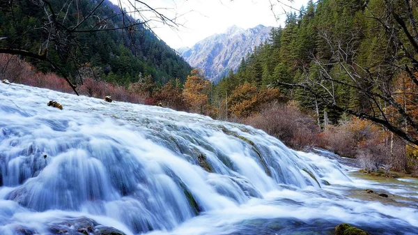Amazing view of the Nuo Ri Lang Waterfall (Nuorilang) among woods and mountains in Jiuzhaigou nature reserve (Jiuzhai Valley National Park) of Sichuan province, China. Fantastic sunny landscape. — Stock Photo, Image