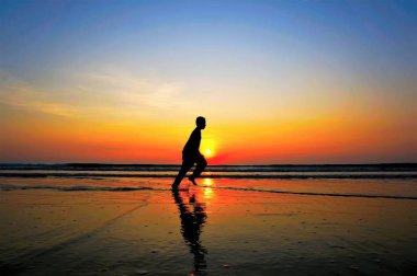 Sahilde koşan adam silüeti