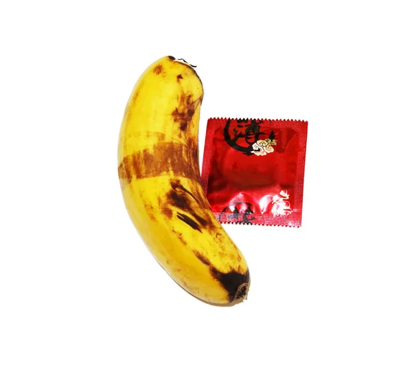 Preservativo Vermelho Uma Banana Fundo Branco — Fotografia de Stock