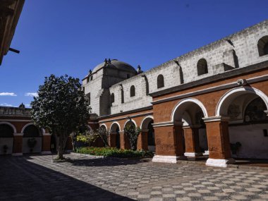 Saint Catherine Manastırı, Arequipa City, Peru 'daki iç avluda. Ağacın aksine manastırın beyaz duvarları ve rahibelerin yaşadığı kırmızı duvarlar vardı. 