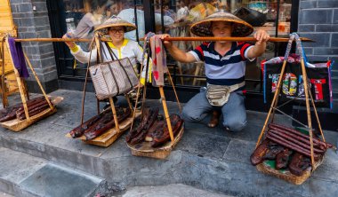Sokak satıcıları füme domuz eti satıyor. Fenghuang şehrinin geleneksel yemek zevki. Fenghuang Antik Kenti, Hunan Bölgesi, Çin
