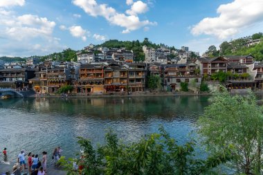 Nehrin diğer yakasının panoramik manzarası. Geleneksel tarzda eski evler Fenghuang Antik Kenti, Hunan Bölgesi, Çin 'deki nehre bakar.
