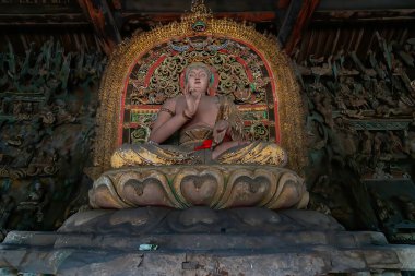 Tahtaya oyulmuş detaylar kazınmış eski bir Buda heykeli. Shuanglin Tapınağı 'nda (veya Zhongdu Tapınağı) bulunan sunak figürü, Pingyao Eski Şehir, Shanxi, Çin
