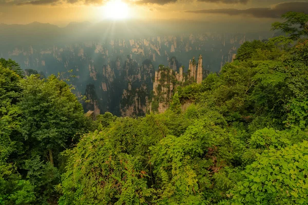 Güneşin ilk ışıkları. Güneş Zhangjiajie dağ sırasının altından yükselir, Ulusal Orman Parkı, Zhangjiajie, Çin