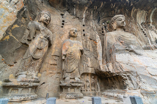 Big statue made in limestone of Vairocana Buddha,  monks and bodhisattvas. The main cave (Fengxiangsi Cave) of Longmen Grottoes in Luoyang . Henan province, China 