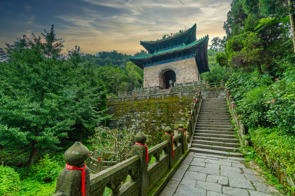 Charming scenery  with cloudy sunset in front of stone staircase leading to old chinese watchtower. Building near Nanyan Palace (South Rock Palace). Wudang Mountain, Hubei province, China