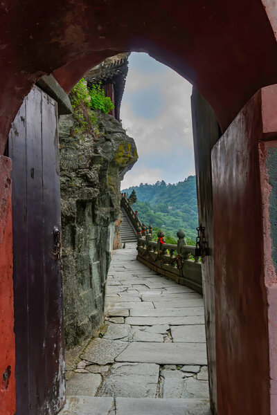 Open door with an arch that leads to Nantianmen path in Nanyan Palace (South Rock Palace). Temple is built on the mountain side of a cliff. Wudang Mountain, Hubei province, China